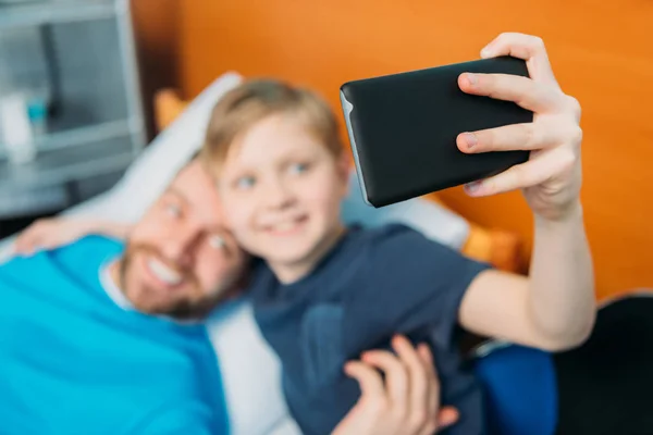 Padre e hijo tomando selfie en sala —  Fotos de Stock