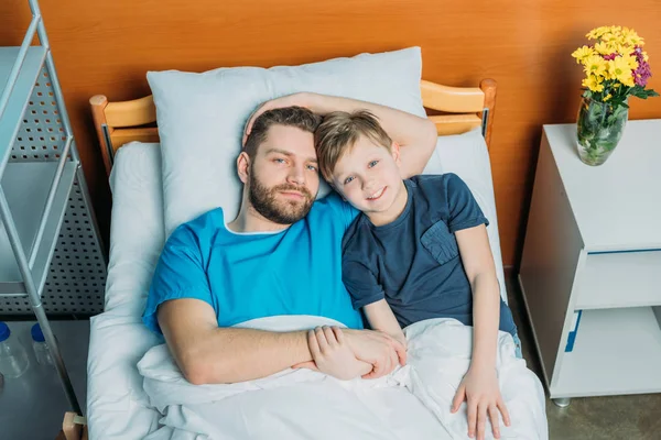 Padre con hijo abrazándose en la sala — Foto de Stock