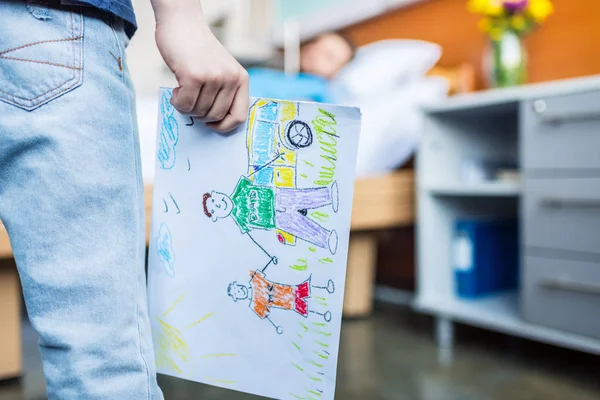 Hijo mostrando dibujos de padre enfermo — Foto de Stock