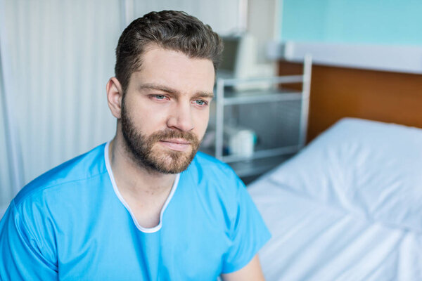 sick man sitting on hospital bed