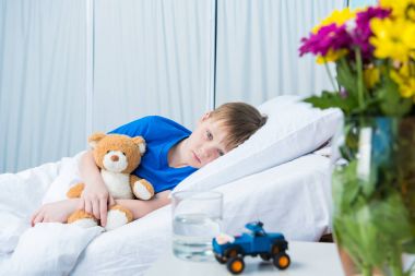 Little boy in hospital bed  clipart