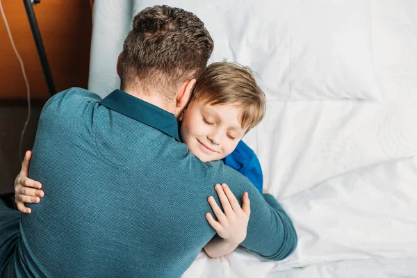 Pequeño hijo abrazando padre — Foto de Stock