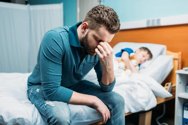 Padre cerca de hijo en cama de hospital — Foto de Stock