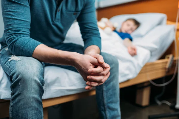Padre cerca de hijo en cama de hospital —  Fotos de Stock