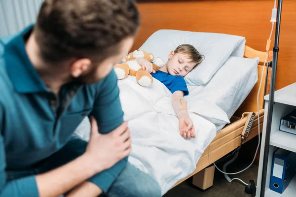 Pai perto filho na cama do hospital — Fotografia de Stock