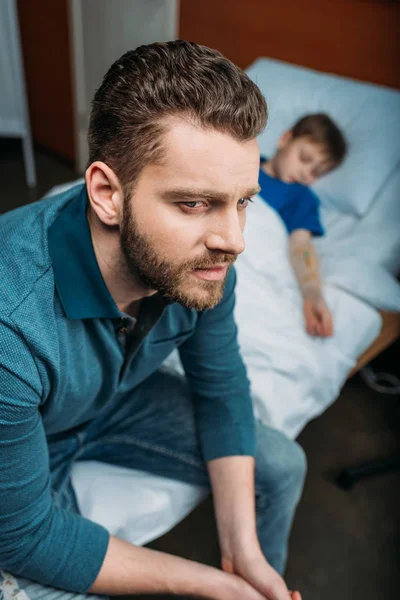 Pai perto filho na cama do hospital — Fotografia de Stock