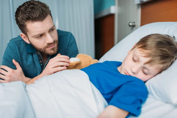 Dad near son in hospital bed — Stock Photo, Image