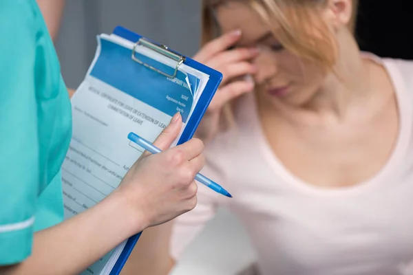 Verpleegkundige met Klembord en overstuur patiënt — Stockfoto