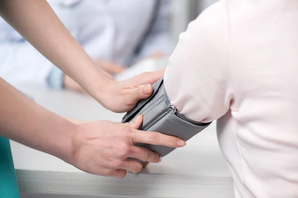 Médico que mede a pressão arterial para paciente — Fotografia de Stock