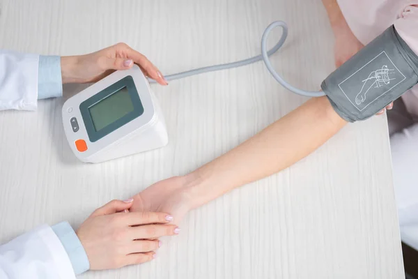 Médico midiendo la presión arterial al paciente — Foto de Stock