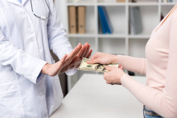 Пациент дает деньги доктору
