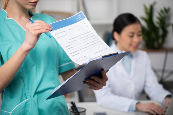 Joven médico con portapapeles — Foto de Stock