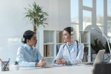 doktor ofisinde hastayla konuşuyor