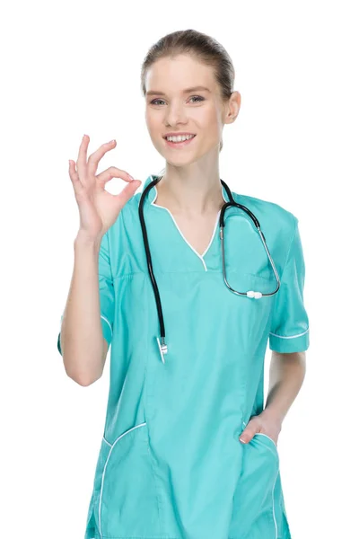 Улыбающаяся медсестра показывает хороший знак — стоковое фото