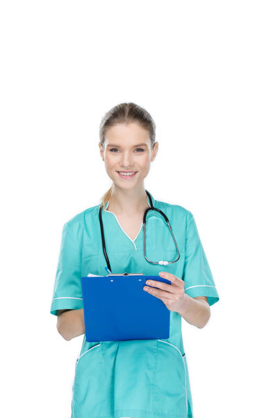 young nurse writing at clipboard