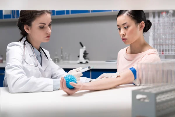 Médico haciendo análisis de sangre de la mujer — Foto de Stock