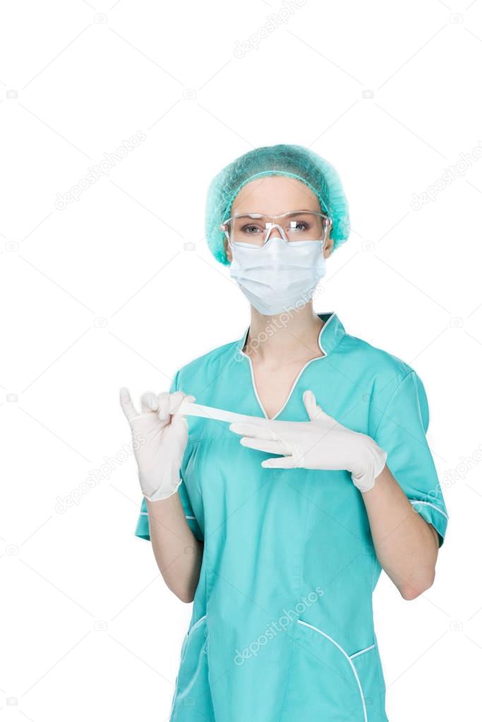 young surgeon taking off medical gloves
