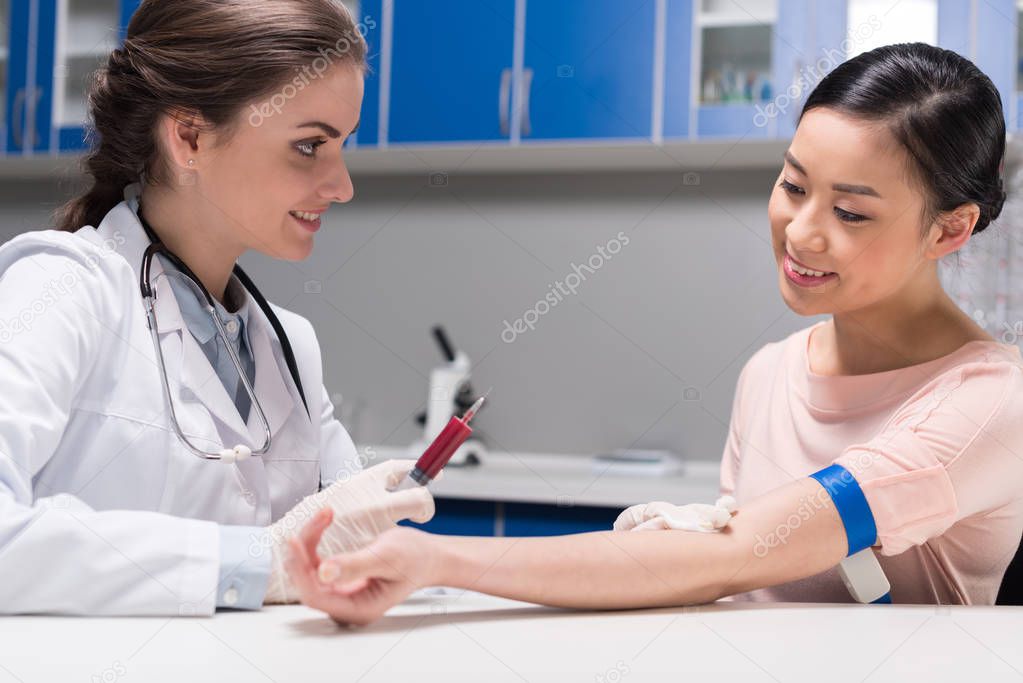 doctor taking blood sample from patient