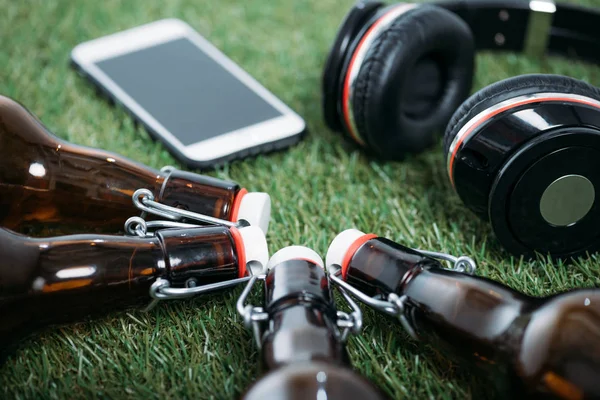 Bottiglie di birra con smartphone e cuffie — Foto Stock