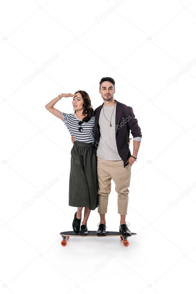 young casual couple standing on skateboard