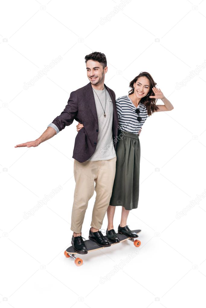 young stylish couple riding on skateboard