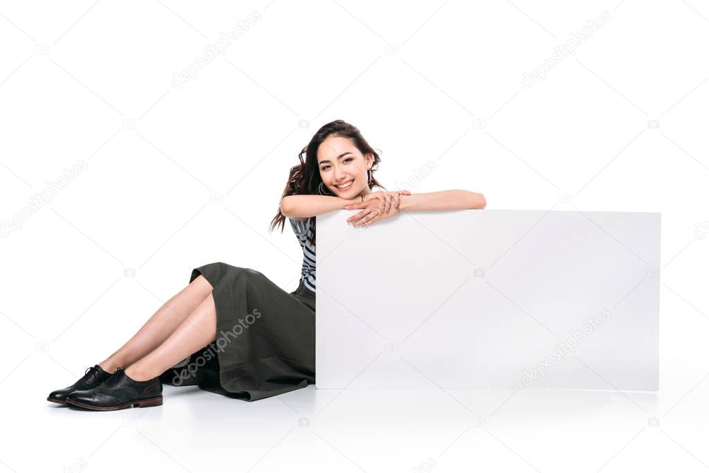 woman sitting and holding blank board