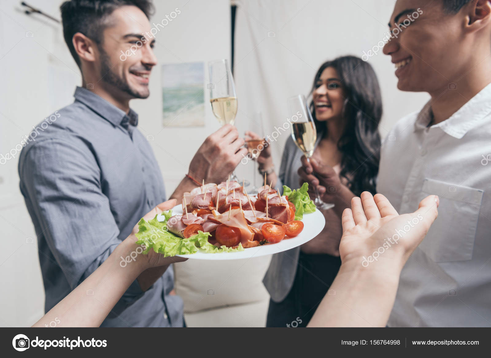 Woman treating friends with snacks at party Stock Photo by ©AlexLipa