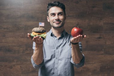 Man with hamburger and apple 