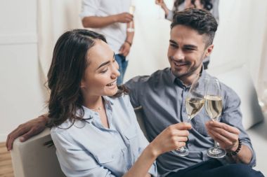 Genç çift ile şampanya bardakları tokuşturup