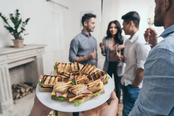 Persona sosteniendo sabrosos sándwiches — Foto de Stock