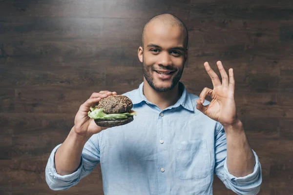 Joven con hamburguesa — Foto de Stock