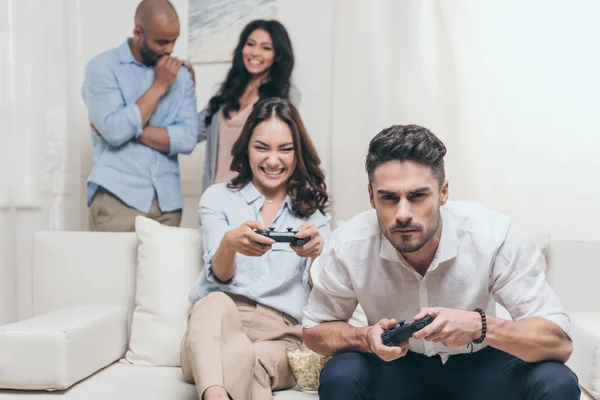 Друзья играют в видеоигры дома — стоковое фото