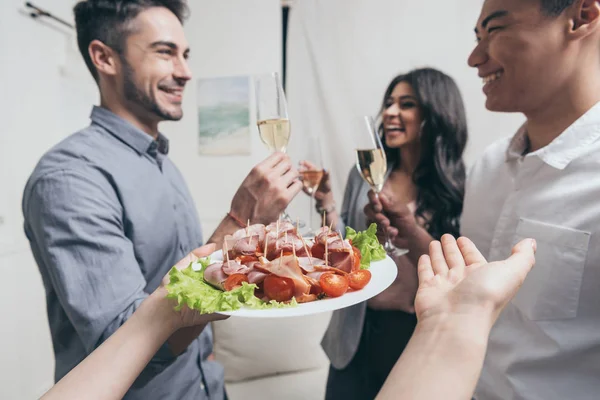 Woman treating friends with snacks at party — Stock Photo, Image