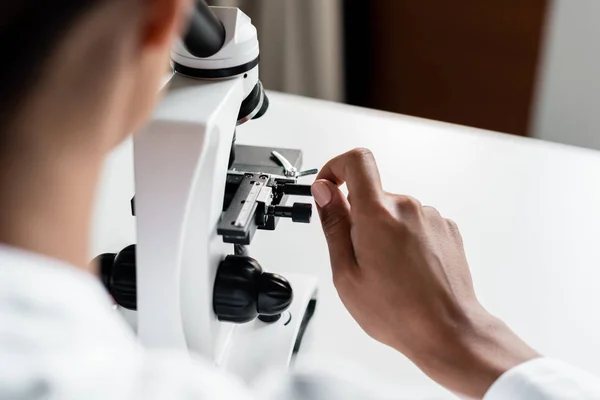Cientista com microscópio em laboratório — Fotografia de Stock