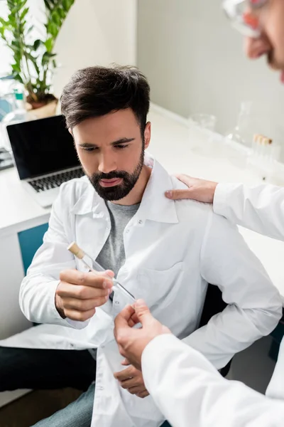 Chemists holding test tube — Free Stock Photo