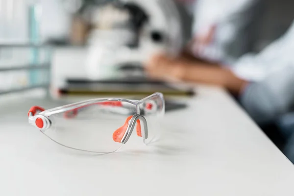 Occhiali protettivi sul tavolo da laboratorio — Foto Stock