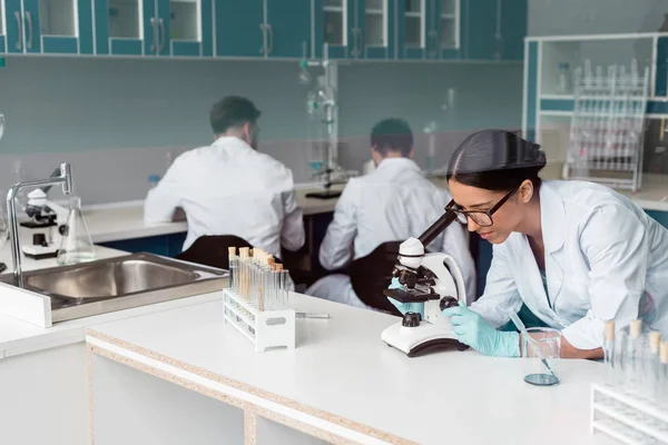 Cientista que trabalha com microscópio — Fotografia de Stock