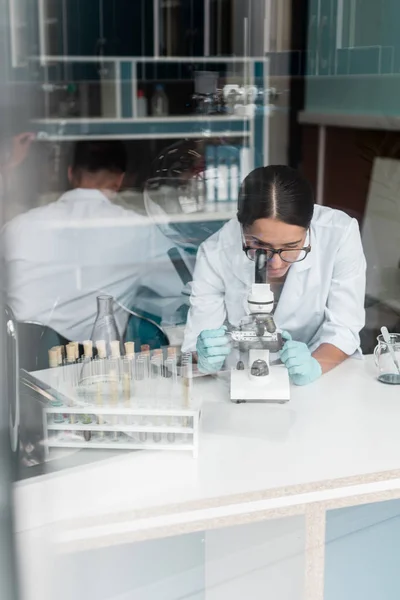 Cientista que trabalha com microscópio — Fotografia de Stock