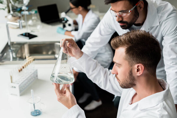 Scientists examining flask 