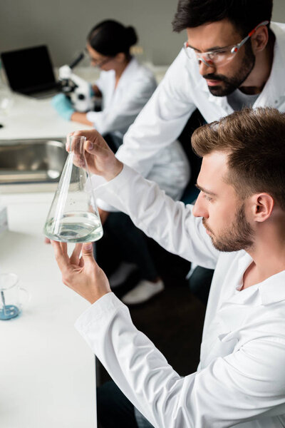 Scientists examining flask 