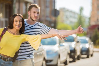 Multiethnic couple hailing taxi clipart