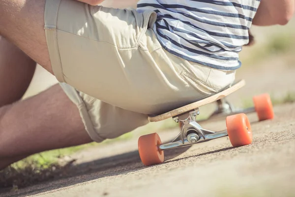 Man sitting on skateboard — Free Stock Photo