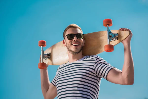 Knappe man met skateboard — Stockfoto