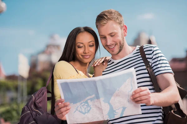 Pareja multiétnica de turistas con mapa — Foto de Stock