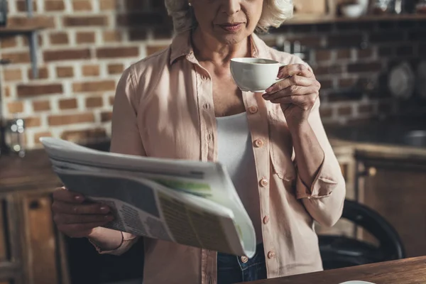Ηλικιωμένη γυναίκα διαβάζει εφημερίδα — Φωτογραφία Αρχείου