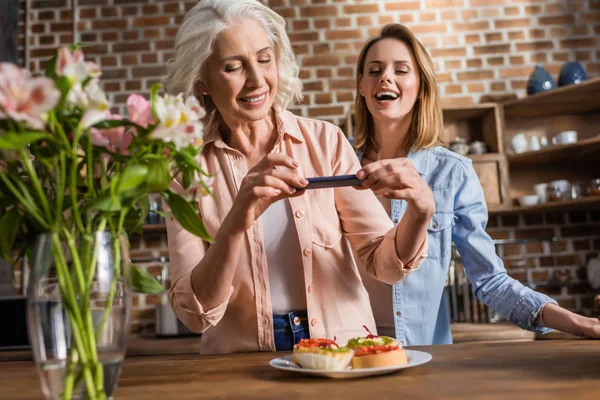 Vrouwen phographing eten in de keuken — Gratis stockfoto