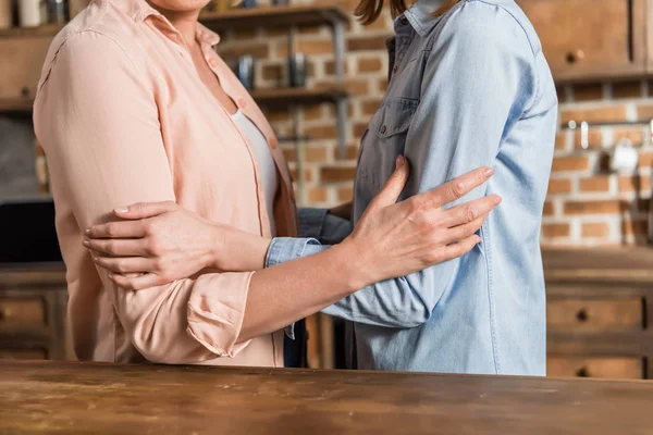 Twee vrouwen knuffelen in keuken — Stockfoto