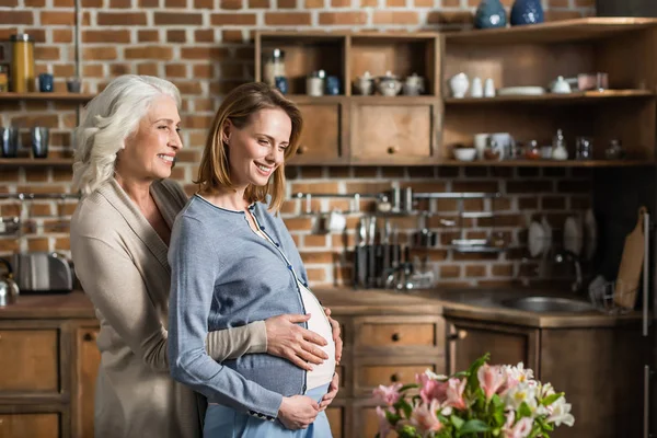 Hamile kadın ve annesi mutfak üzerinde — Stok fotoğraf