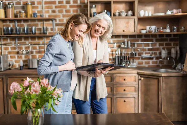 Mujer embarazada y su madre en la cocina — Foto de Stock