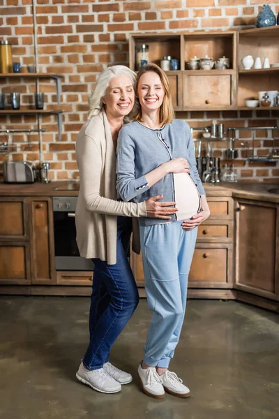 Вагітна жінка і її мати на кухні — стокове фото